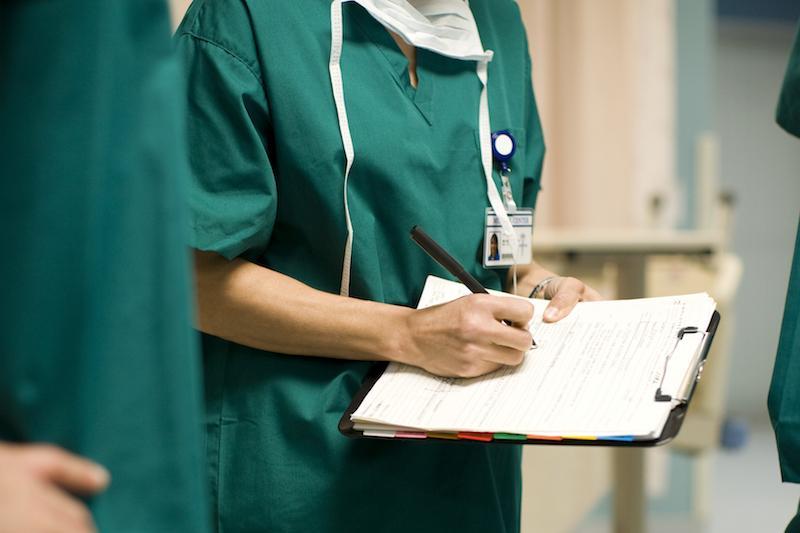 Healthcare workers writing on a clipboard 